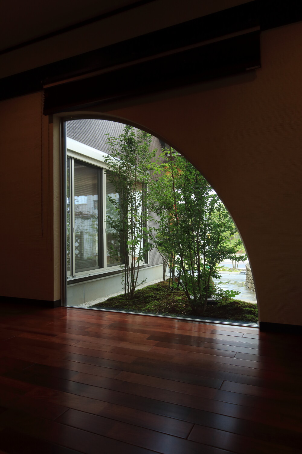 室内の広い廊下から中庭を眺める為の窓は扇状の形で特注のデザインを施して風景と庭の見える角度と印象をデザインしていますそれは同時に外観の印象と佇まいにも良い影響を及ぼしています