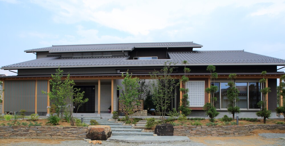 旅館や料亭のようなイメージを和モダンで表現した平屋のった住まいを持つ木造二階建ての高級住宅の外観