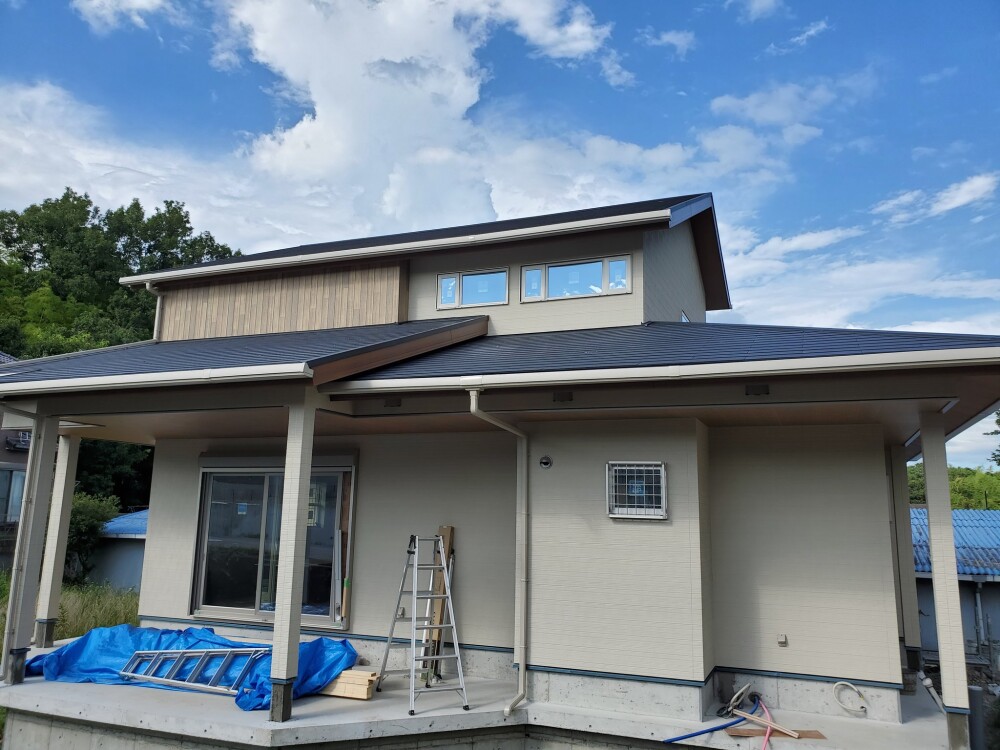深い軒と二段屋根が連なる奈良県の和モダン住宅外観。木目パネルの垂直アクセントと陰影のデザインが立体感と落ち着きを生む。