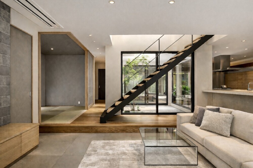 中庭の水盤と植栽をガラス越しに取り込み、鉄骨階段がリビングを横断する和モダン住宅。ホテルライクな静けさの中で、暮らしの関係性を整える建築家の設計視点を表現した空間。