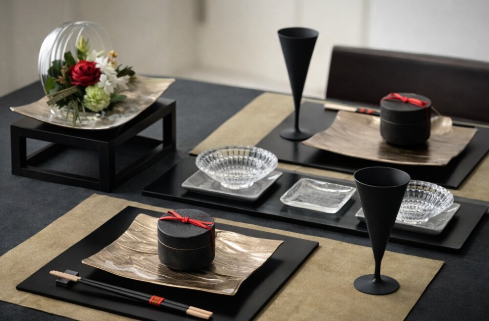 和モダンのダイニングに整えられたテーブルウェア。 黒と生成りを基調にした器構成の食卓で、箸は日本文化に則り横向きに配置され、箸先を左にして箸置きに正しく置かれている。 器・箸・余白が静かに調和し、食事の所作まで美しく整える設え。