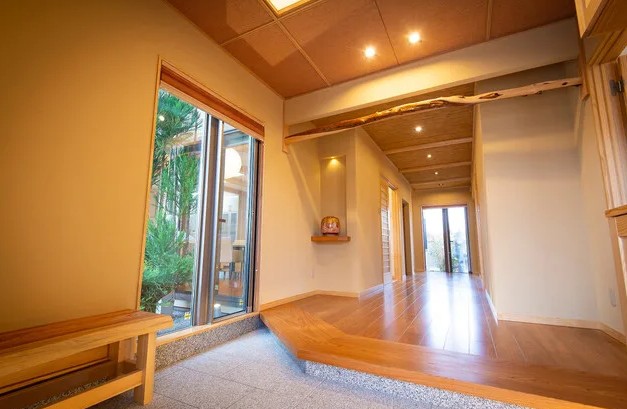 奈良県磯城郡に建つ、数寄屋をイメージした和モダン住宅の玄関空間。 土間から上がり框へと続く段差と奥行きのある動線により、 住まい手の振る舞いや気持ちの切り替えを自然に導くよう設計された住まい。 光と陰影、視線の制御によって、暮らしの質を静かに整える玄関。 設計:やまぐち建築設計室。