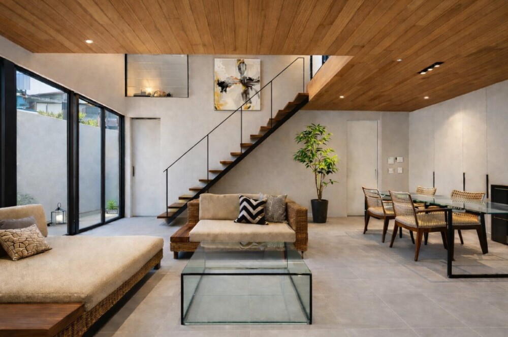 奈良の建築家が設計した和モダン住宅のLDK空間。朝日ウッドテックTHE WALLヘムロック天井と大開口サッシが特徴のホテルライクなリビングダイニング。中庭の植栽と自然光を取り込み、吹き抜け階段とガラス手摺が空間の広がりを生む、暮らしの質を高める注文住宅のインテリアデザイン。