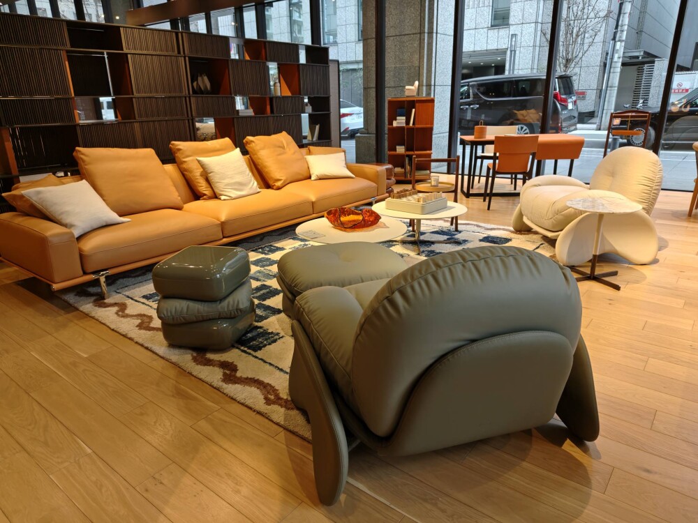 ポルトローナ・フラウのレザーソファを中心に構成された大阪ショールームのリビング空間。大開口の窓から自然光が差し込み、木質フローリングと家具の素材感が調和することで、和モダンにも通じる上質な居心地を実現したインテリア設計。