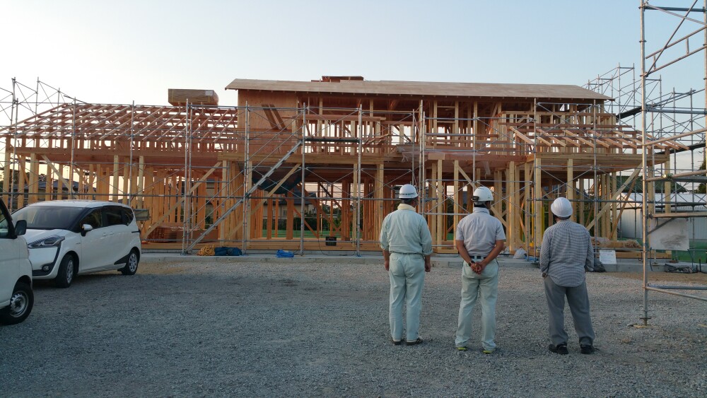 奈良県で注文住宅を建築中の木造住宅の構造躯体確認の様子。上棟後の現場で設計者と施工会社が建物全体を確認しながら施工品質や構造、安全性をチェックしている場面。良い工務店選びや現場管理、設計監理の重要性を伝える家づくりの現場風景。