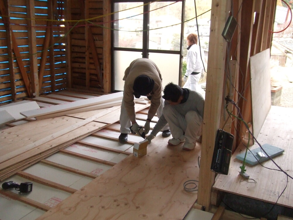 奈良県の戸建て住宅で進むLDKリフォーム工事の様子。既存の内装を解体した室内で、大工が床下断熱材と床下地を施工し、家事動線や間取りを改善する改修を進めている。