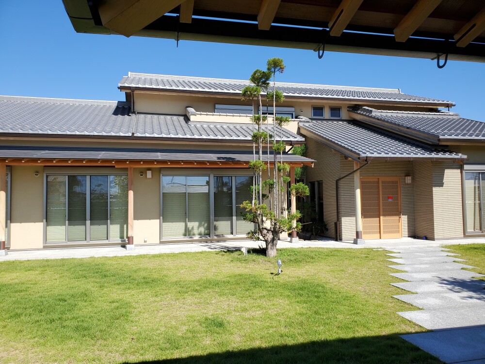 深い軒と瓦屋根、剪定された松、芝生の庭が調和する奈良の数寄屋住宅。建物・庭・玄関アプローチを一体で計画し、和の暮らしと庭の維持管理を両立した設計実例。