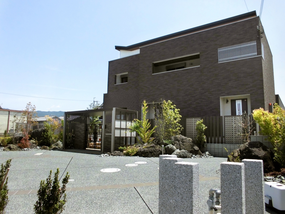 自然石と植栽を組み合わせた和モダン住宅の庭。外構と建物が調和し、四季を感じる落ち着いた住環境を実現。