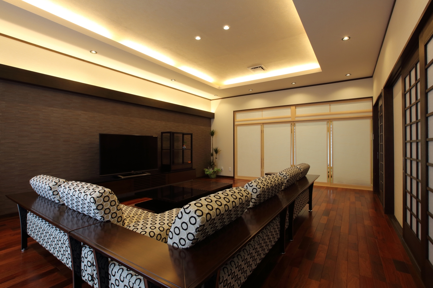 建築家が設計した奈良の和モダン注文住宅のリビング空間。間接照明と折り上げ天井、障子と無垢材の床が調和し、静けさと上質さを備えたホテルライクな住まい。